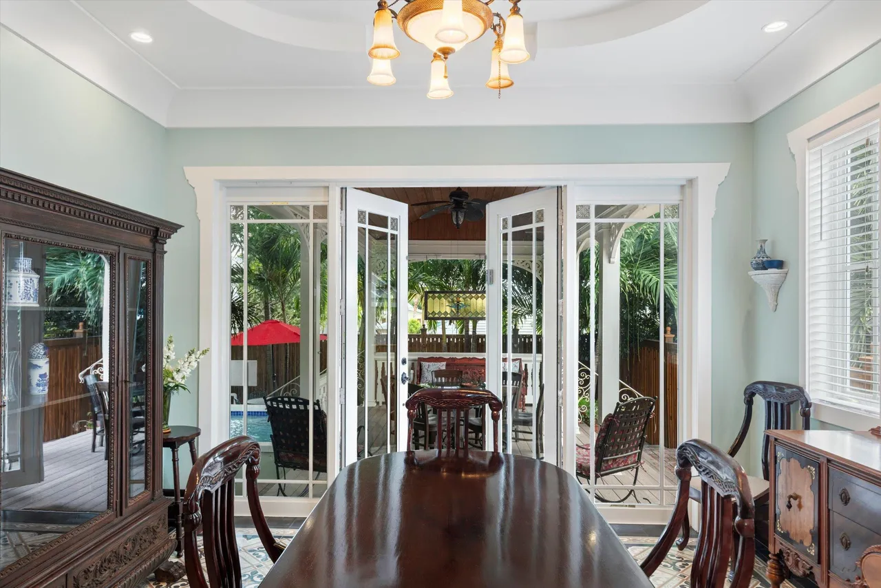 Formal dining room opening to the pool patio through French doors