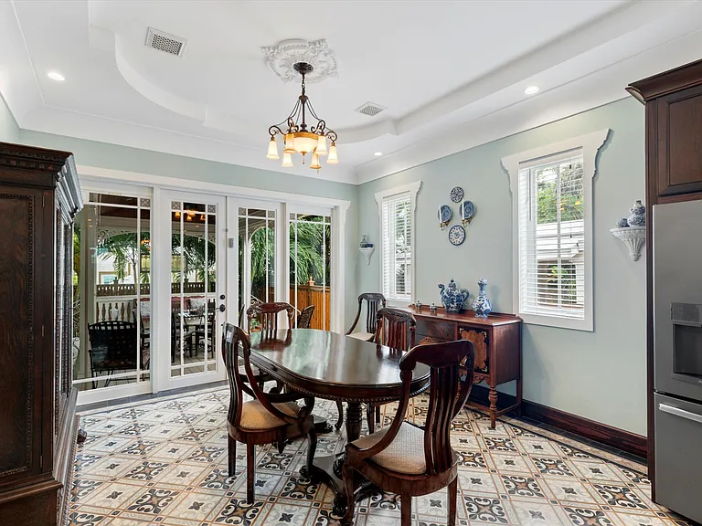 Elegant dining room with tray ceiling and patterned tile floor